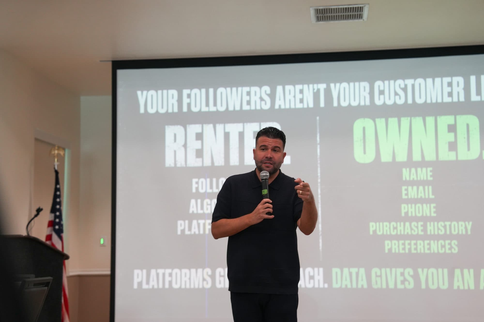 Carlos Gil on stage in front of the “Your followers aren’t your customer list” slide